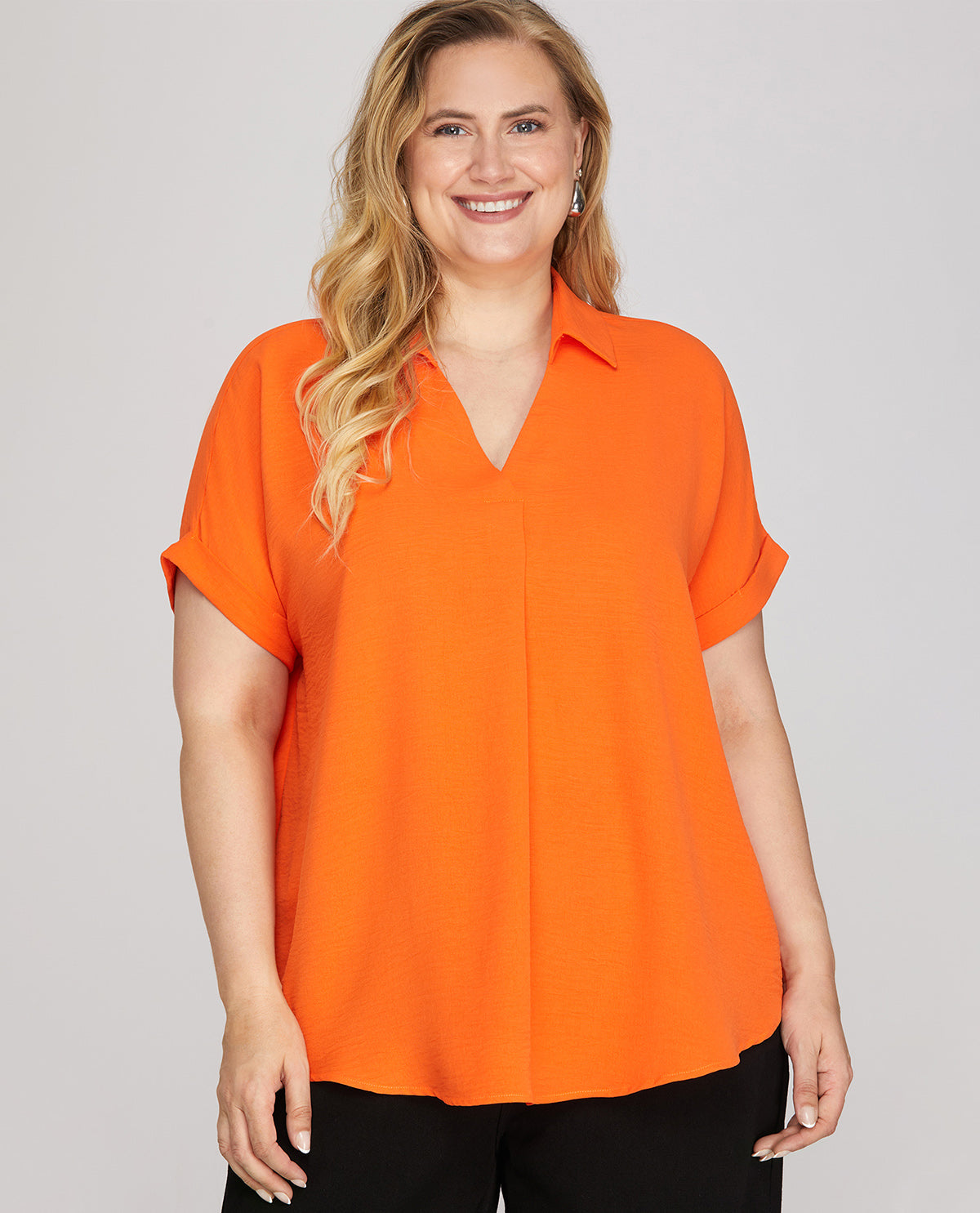 Woman wearing an orange blouse against a gray background