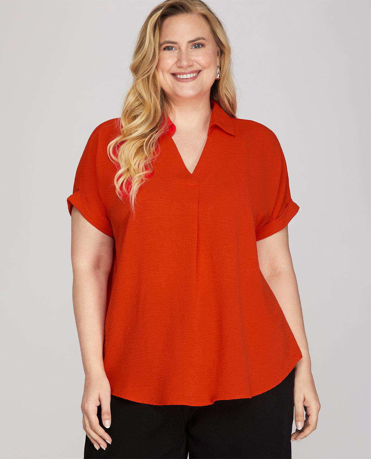 Woman wearing a red blouse against a gray background