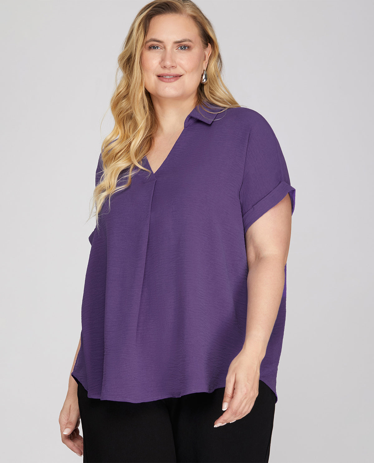 Woman wearing a purple blouse against a plain background