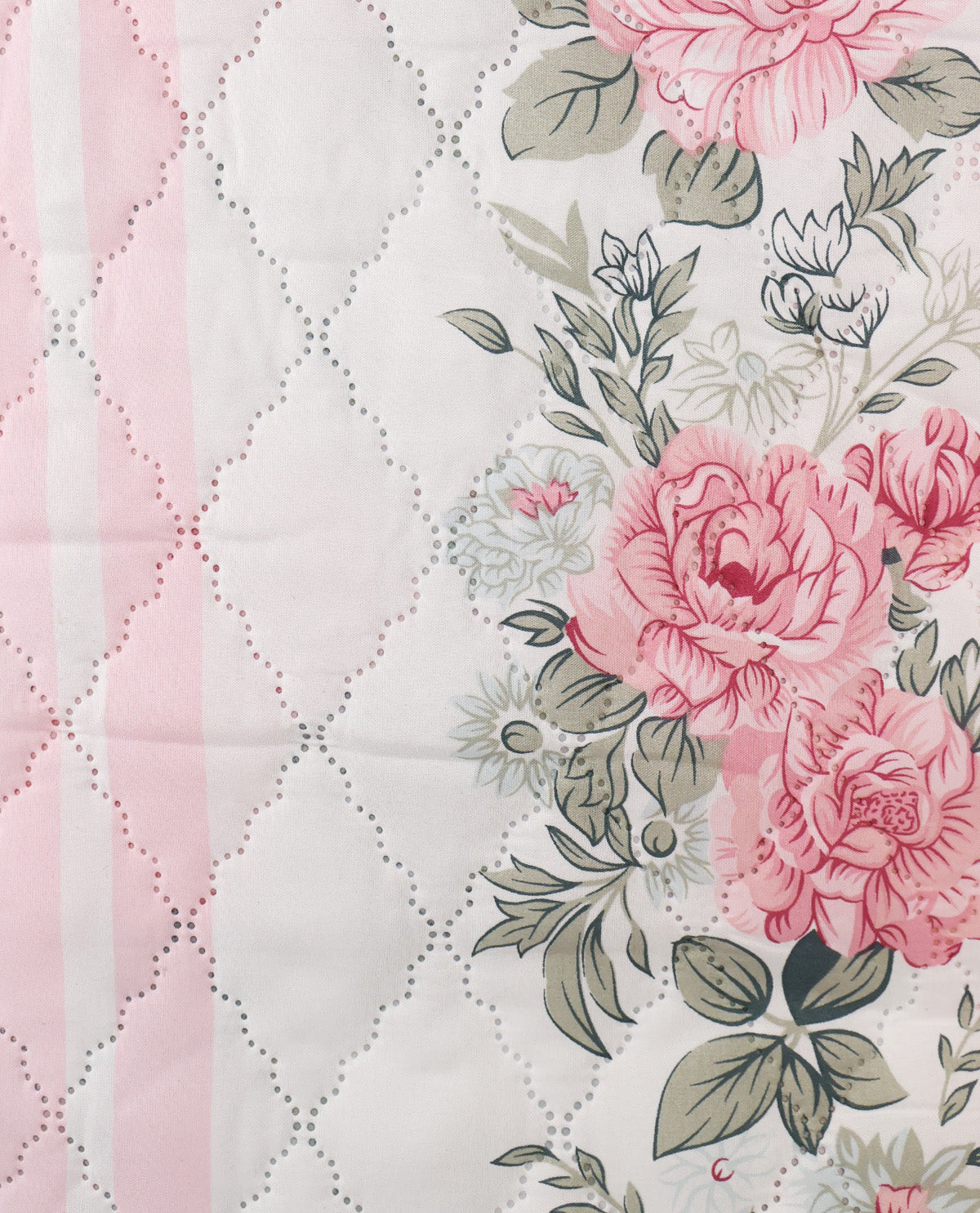 A close-up of a quilted fabric featuring a split design: one side has a light pink and white diamond-quilted pattern, and the other side displays a floral print with large pink peonies, green leaves, and small white flowers on an off-white background.