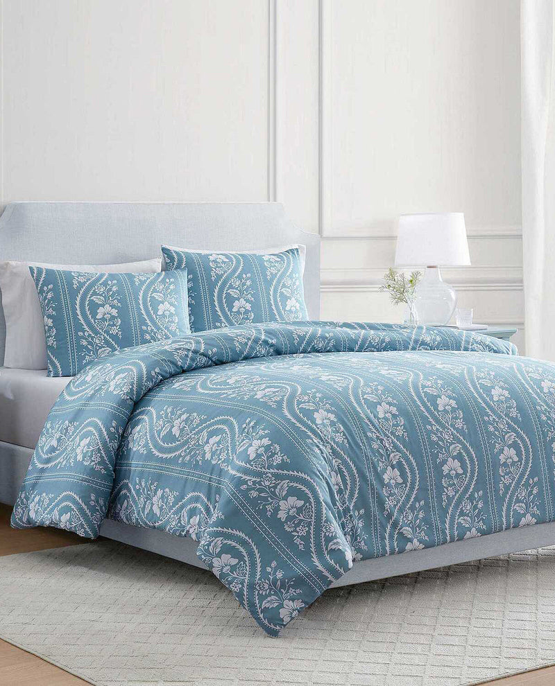 A light blue and white patterned bedding set with a duvet cover and two matching pillowcases, styled on a bed in a bright bedroom setting.