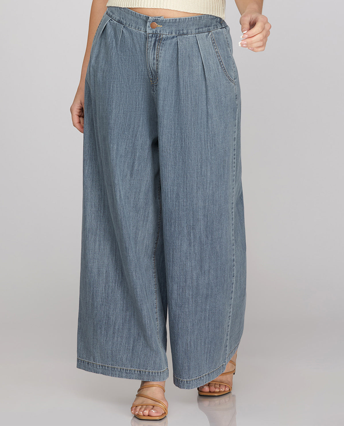 Person wearing light blue denim wide-leg pants on a plain background