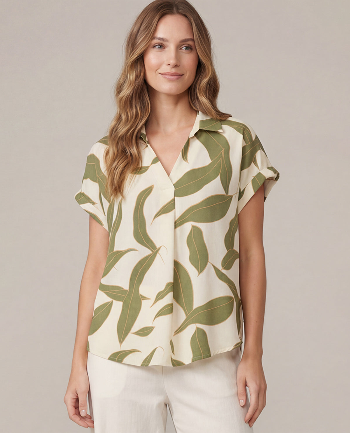 Woman wearing a leaf-patterned shirt against a plain background