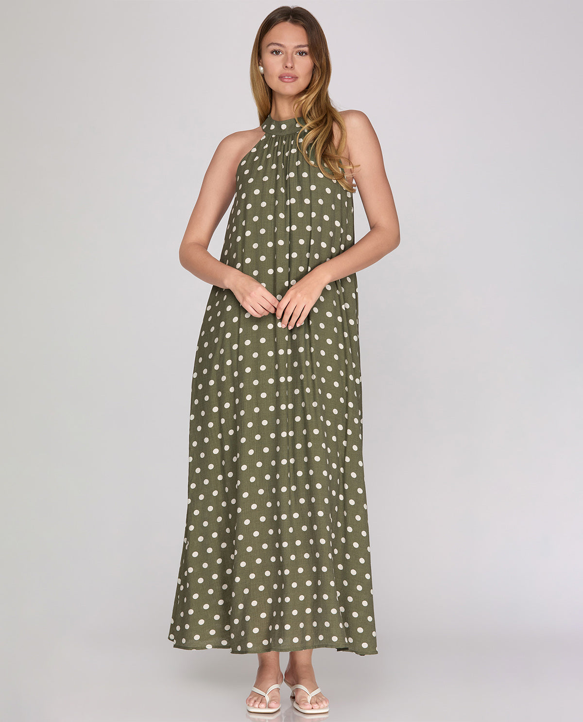 Woman wearing a green polka dot dress on a white background