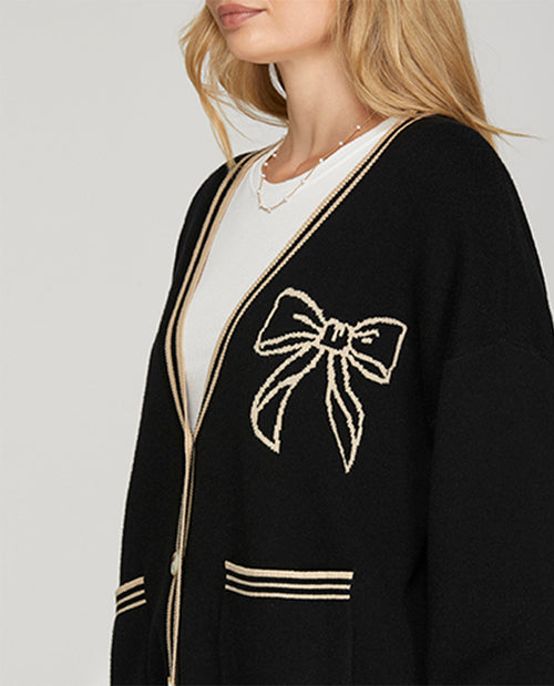 Black cardigan with a bow design on a plain background