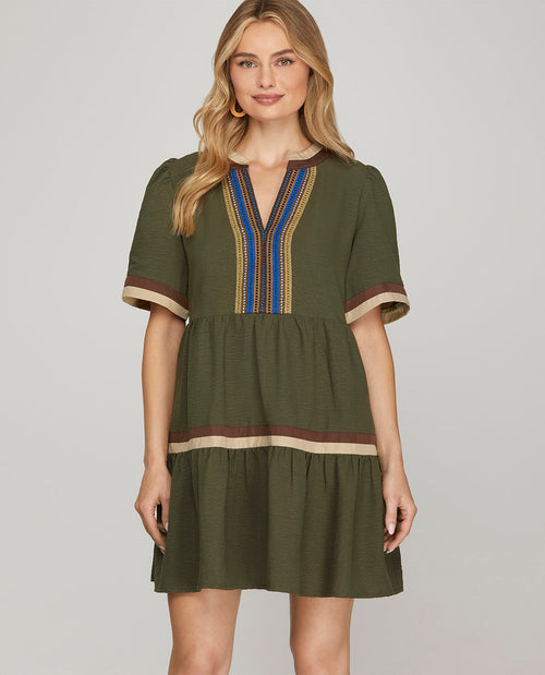 Missy model wearing a short sleeve olive mini dress with multicolor trim