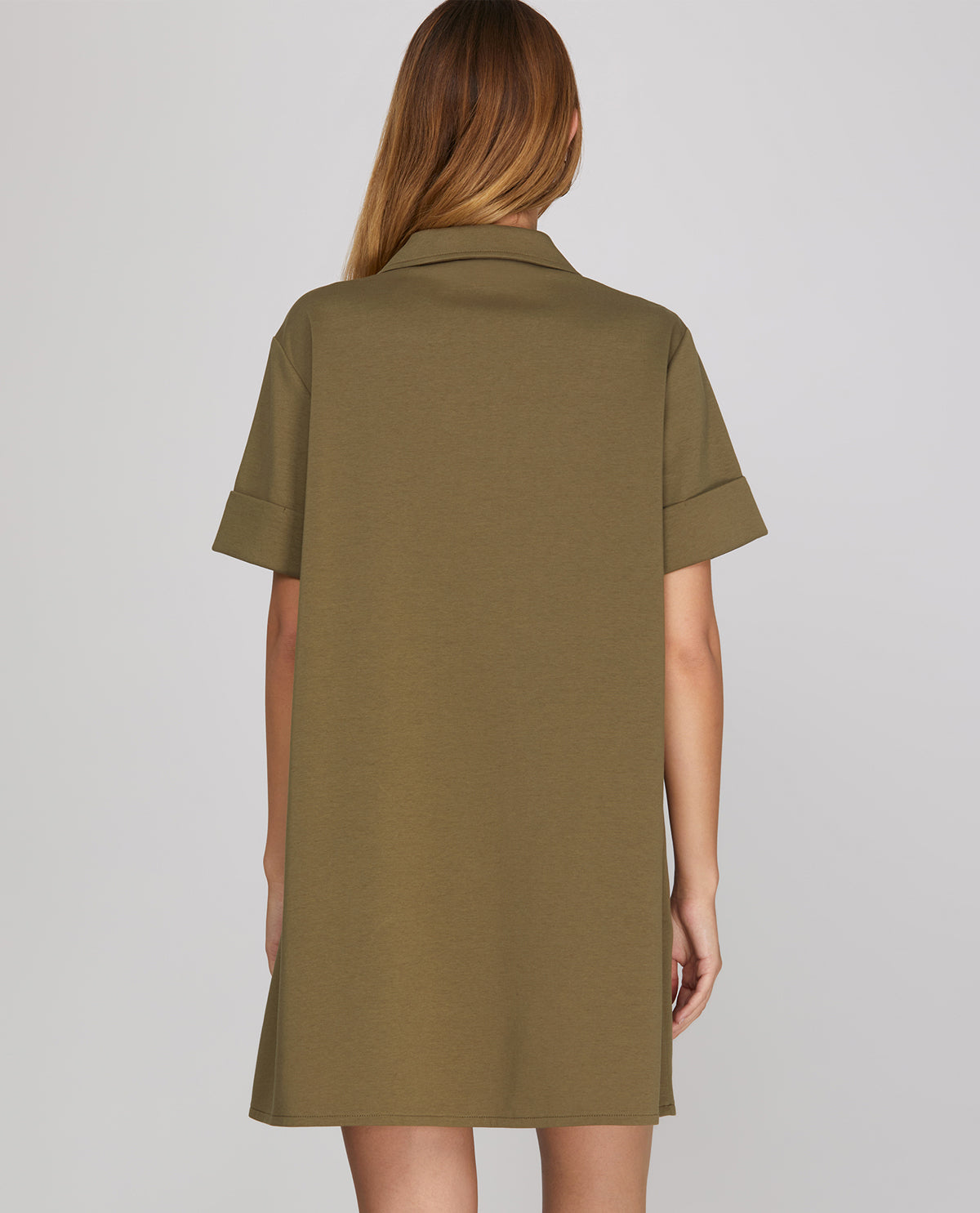 Green dress worn by a person on a gray background