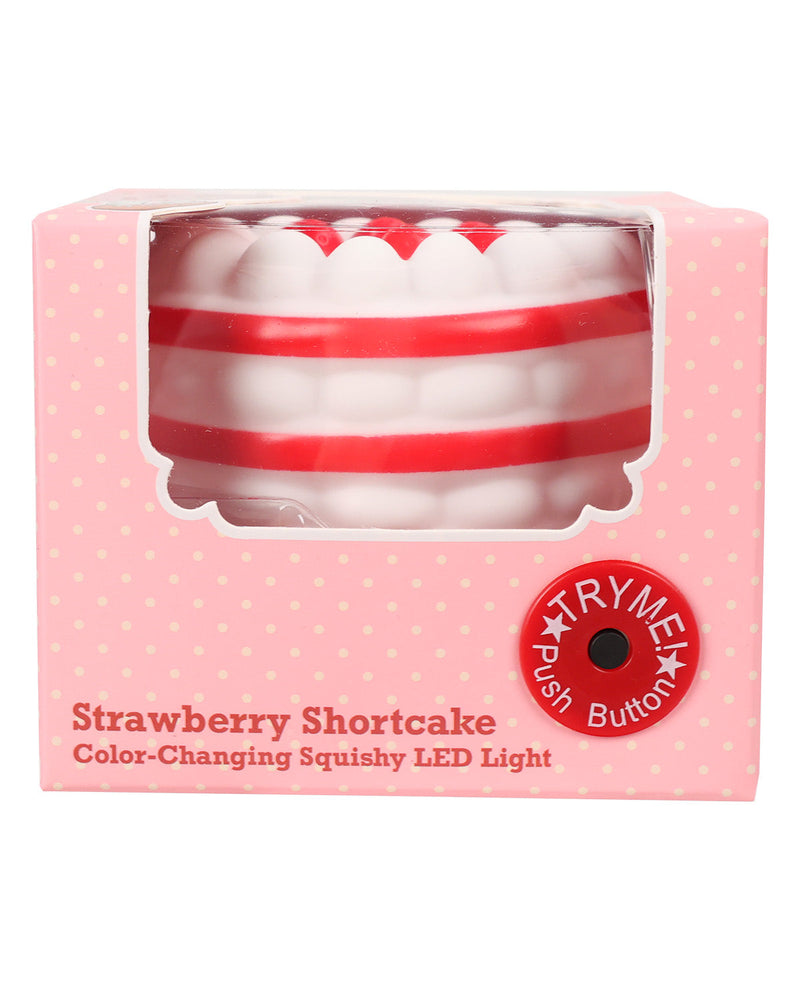 A boxed strawberry shortcake-themed LED light shaped like a slice of cake with red and white stripes, shown in its pink retail packaging with a clear window and a red 'Try Push Button' badge.
