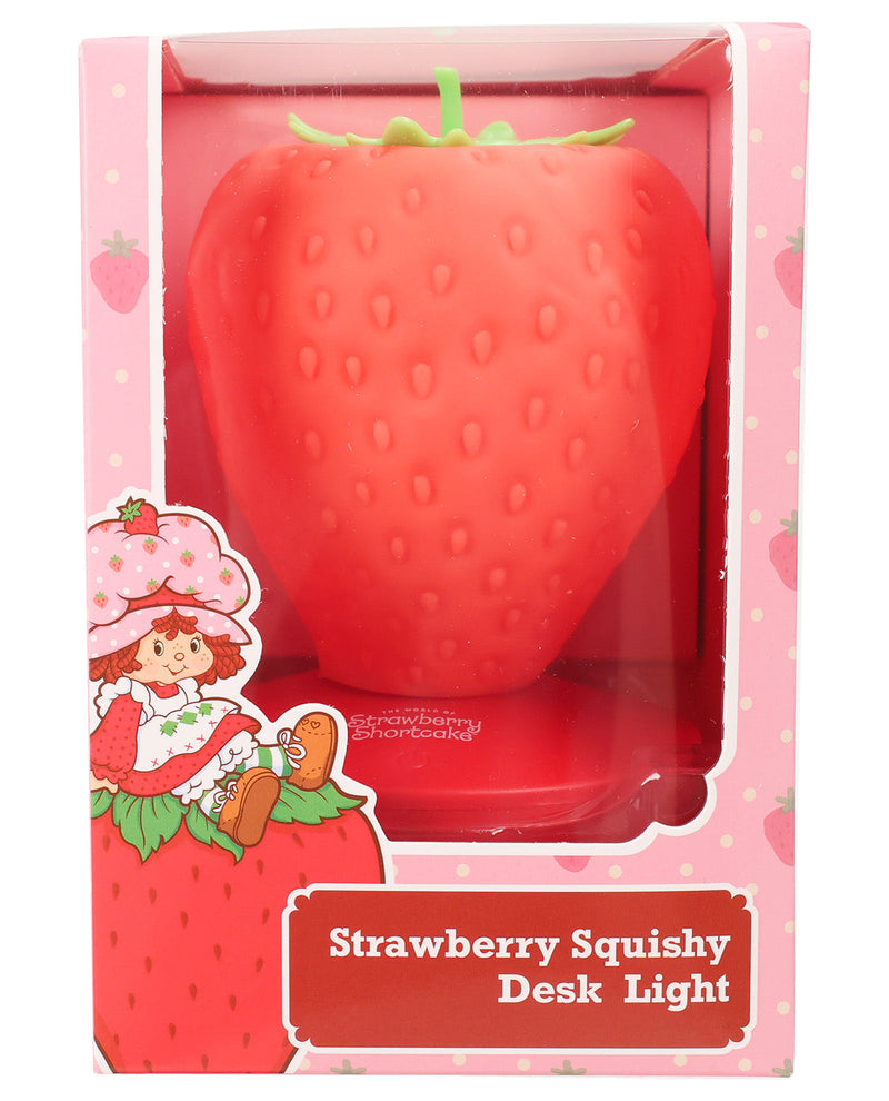 Strawberry-shaped squishy desk light in its original pink packaging, featuring a red strawberry-shaped light with green stem details and Strawberry Shortcake illustration on the box.
