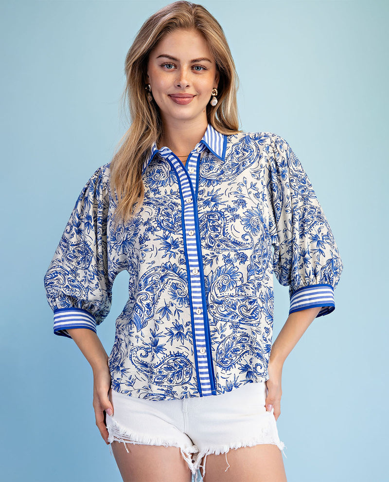 Woman wearing a blue and white patterned shirt with a blue background