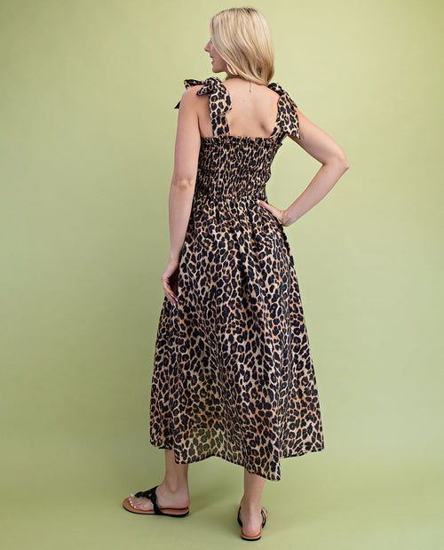 Woman wearing a leopard print dress against a green background