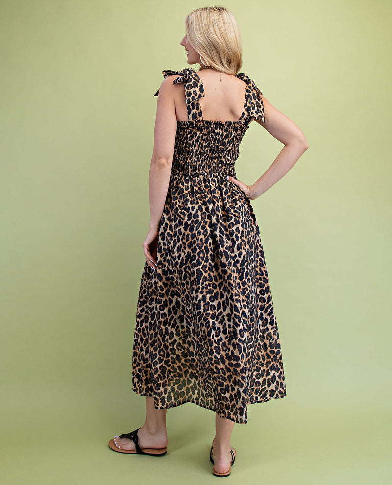 Woman wearing a leopard print dress against a green background