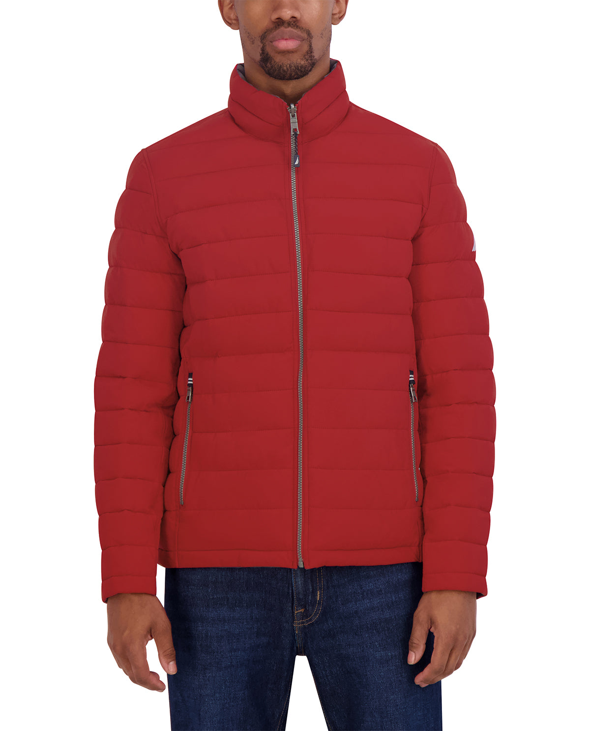 A man wearing a red puffer jacket with a stand-up collar and front zipper, paired with blue jeans, shown against a plain white background.